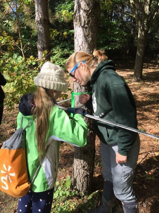 student measuring tree width with calipers